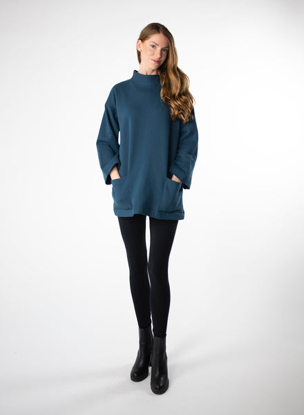 Deep Blue Organic Cotton Fleece tunic length sweater with full sleeves. Features front pockets and wide collar. Styled with black leggings