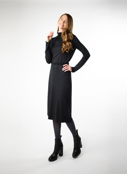Black mock neck dress with full length sleeves. Dress length ends below the knee. Styled with Charcoal Grey leggings and black belt around the waist. Tencel Modal blend lux fabric.