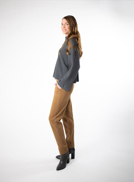 Charcoal waffle knit cropped sweater. Wide mock neck style neckband and full sleeves. Styled with Nutmeg trousers.