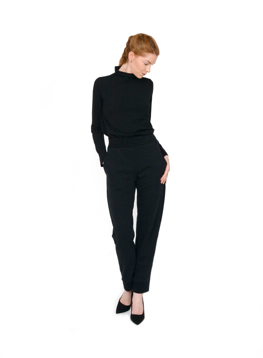Black unisex mock neck, fitting close to the body with full length sleeves. Styled with Black unisex trousers.
