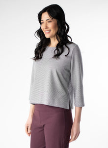  Grey and white striped hip length top with 3/4 length sleeve. Pin tuck on shoulder seam. Bamboo and Cotton fabric. Styled with burgundy pants