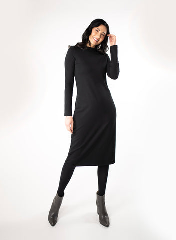 Black dress with full length sleeve and mock neck. With black tights and grey boots.