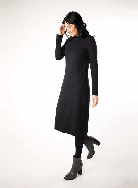 Black dress with full length sleeve and mock neck. With black tights and grey boots.