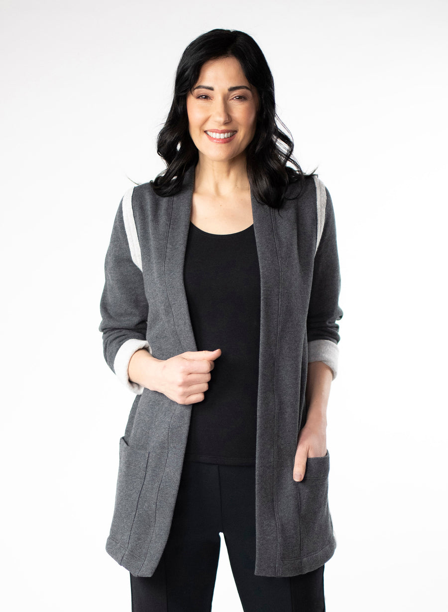 Charcoal Grey Fleece Cardigan with reverse fabric trim. Front pockets at hip. Styled with Black fitted tank and pants.