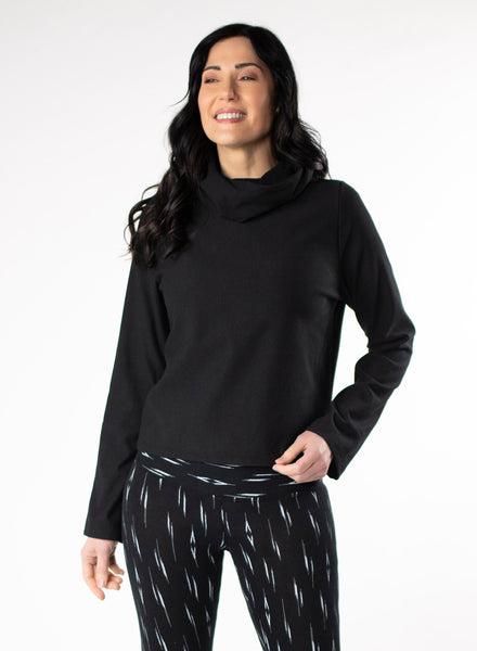 Black Fleece cropped sweater with dual cowl neck and fitted hood. Pleat at centre back hem. Styled with Black and White patterned leggings