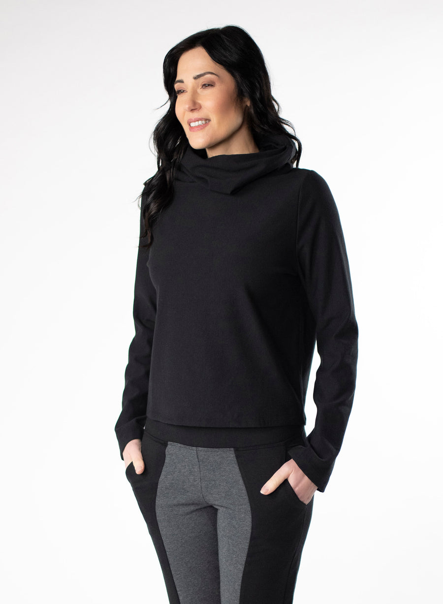 Black Fleece cropped sweater with dual cowl neck and fitted hood. Pleat at centre back hem. Styled with Black and Charcoal fitted pants