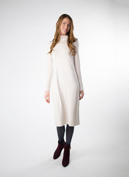 Cream mock neck dress with full length sleeves. Dress length ends below the knee. Styled with Charcoal Grey leggings. Tencel Modal blend lux fabric.
