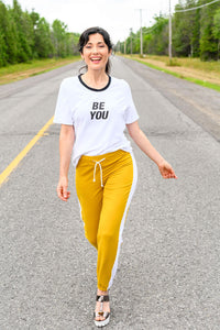 Relaxed white tshirt with 'Be You' front graphic and black neckline trim with a relaxed fit and rounded hemline.