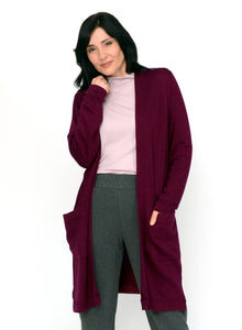 Burgundy long open cardigan with front pockets. Tencel Modal blend lux fabric. Styled with light pink ribbed mock neck and charcoal grey fitted pants