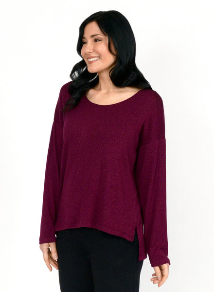 Burgundy long sleeve top with boat neck and relaxed fit to the body. Step hem with a small side slit. Tencel Modal blend lux fabric
